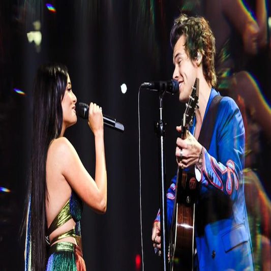 Ariana Grande and Harry Styles perform on stage together.