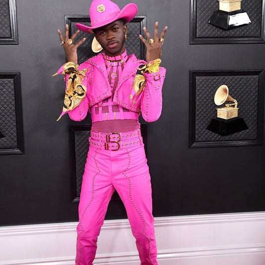Lil Nas X wearing a hot pink cowboy outfit standing in front of a Grammy Awards backdrop - Found on the Blog Page of Topline Vocals website vokaal.com